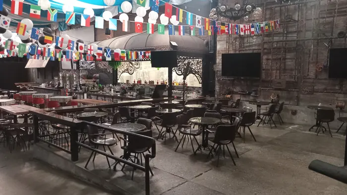 Tables and chairs arranged under decorative lights at Red Macaw