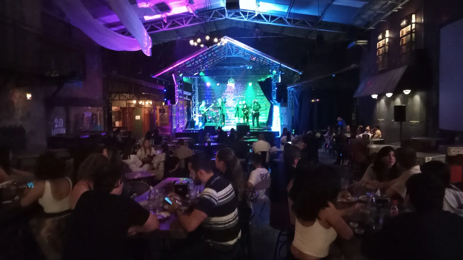 Live band on Red Macaw’s lit stage, with guests watching from tables